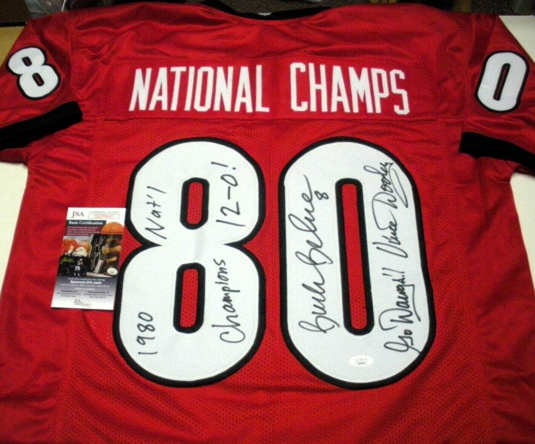 Signed Georgia Bulldogs 1980 National Champions Jersey JSA COA Dooley Belue: Signed Georgia Bulldogs 1980 National Champions Jersey JSA COA Dooley Belue This pre-owned jersey is signed by Vince Dooley and Buck Belue, commemorating the 1980 National Champions with the "Go Dawgs