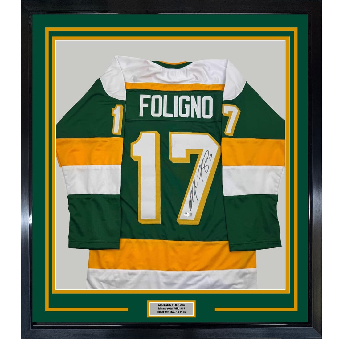 Marcus Foligno signed green hockey jersey framed BAS COA 35x39: Marcus Foligno signed green hockey jersey framed BAS COA 35x39 This professionally framed and matted green hockey jersey is autographed by Marcus Foligno. The display includes two 5x7 photos and measu
