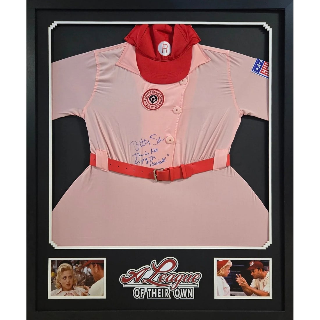 JSA Authenticated Bitty Schram Framed Dress A League Of Their Own: JSA Authenticated Bitty Schram Framed Dress A League Of Their Own This framed dress from "A League Of Their Own" is autographed by Bitty Schram. The display features detailed framing and a prominent l
