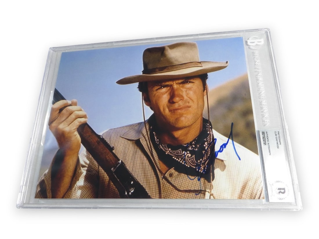 8x10 Photograph Signed by Clint Eastwood with Beckett Authentication: 8x10 Photograph Signed by Clint Eastwood with Beckett Authentication This is an original 8x10 photograph featuring Clint Eastwood in a classic Western pose with a gun. The photo is hand-signed by Clin