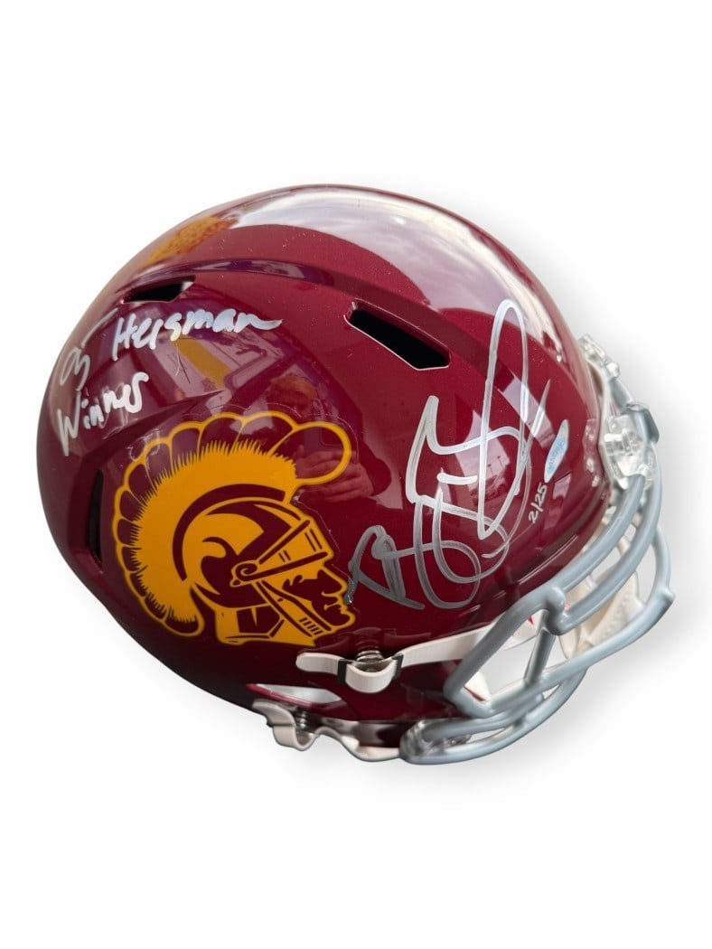 USC Trojans Full Size Helmet Signed by Reggie Bush UDA 2 of 25 Heisman Inscription: USC Trojans Full Size Helmet Signed by Reggie Bush UDA 2 of 25 Heisman Inscription This is a full-sized helmet autographed by Reggie Bush, featuring the inscription "05 Heisman Winner." The helmet is 