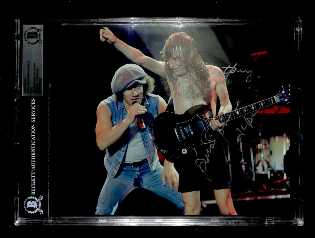 8x10 Photograph Signed by Angus Young and Brian Johnson with Beckett Authentication: 8x10 Photograph Signed by Angus Young and Brian Johnson with Beckett Authentication This is an autographed 8x10 color photograph featuring signatures from Angus Young and Brian Johnson of AC/DC. The s