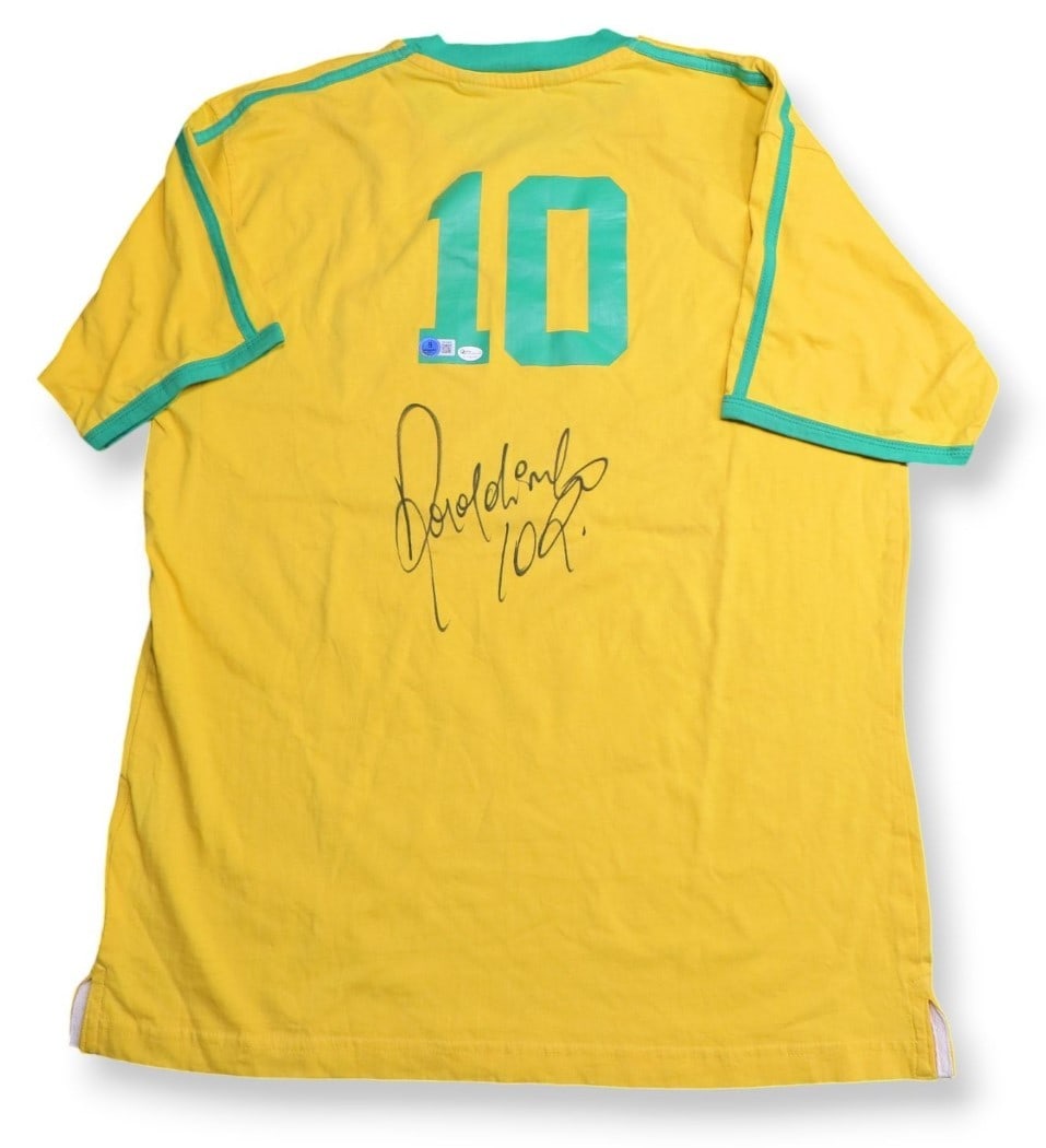 Ronaldinho Autographed Team Brazil Jersey Yellow Beckett Authenticated: Ronaldinho Autographed Team Brazil Jersey Yellow Beckett Authenticated This authentic Team Brazil jersey, signed by the legendary soccer player Ronaldinho, is a must-have for any fan. The jersey comes