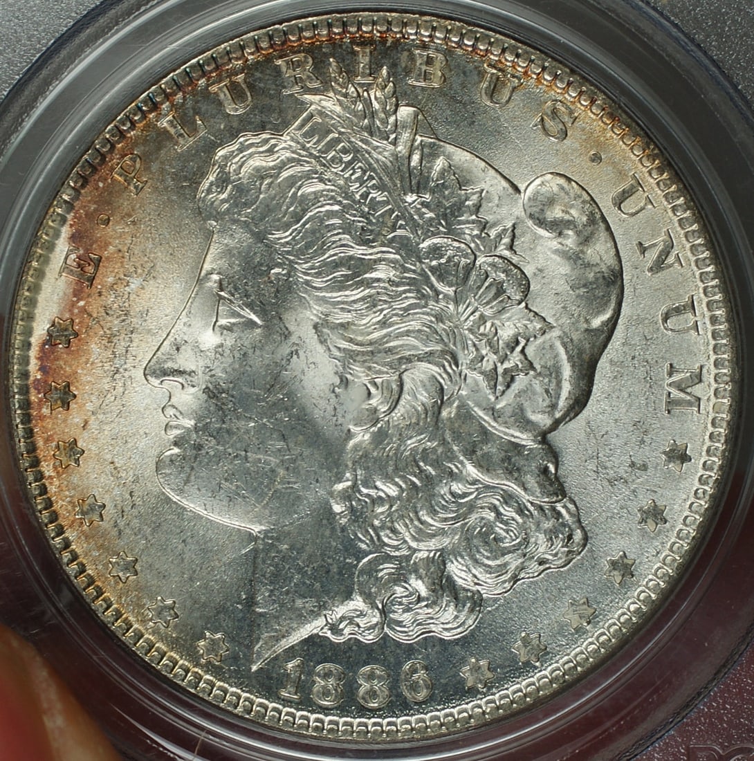 1886 PCGS MS-62 Morgan silver dollar Philadelphia mint: 1886 PCGS MS-62 Morgan silver dollar Philadelphia mint This 1886 Morgan Silver Dollar is graded MS-62 by PCGS and is uncirculated. The coin features light toning around the rim and was minted in Phila