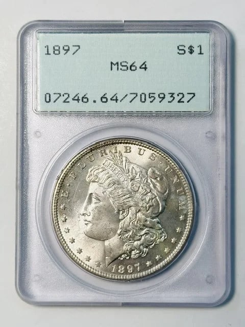 PCGS MS-64 1897 Morgan Silver Dollar Philadelphia: PCGS MS-64 1897 Morgan Silver Dollar Philadelphia Pre-owned 1897 Morgan Silver Dollar certified by PCGS and graded MS-64. This silver dollar is struck for the USA and housed in a rattler holder. Speci