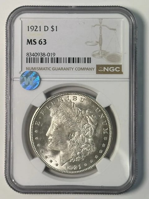 NGC MS 63 1921 D Morgan Silver Dollar: NGC MS 63 1921 D Morgan Silver Dollar 1921 D Morgan Silver Dollar certified by NGC and graded MS 63. The coin is described as Sight White and is pre-owned. It is a silver dollar from the United States
