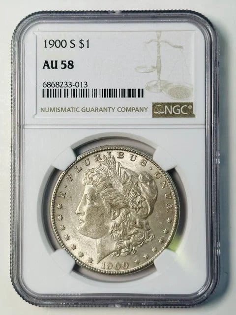 NGC AU 58 1900 S Morgan Silver Dollar Coin: NGC AU 58 1900 S Morgan Silver Dollar Coin 1900 Morgan Silver Dollar certified by NGC and graded AU-58. This pre-owned silver dollar was minted in San Francisco and has a one dollar denomination. Spec
