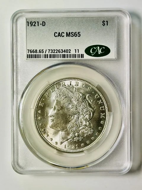 1921 Denver Morgan Silver Dollar CAC MS 65: 1921 Denver Morgan Silver Dollar CAC MS 65 This 1921 Morgan Silver Dollar was minted in Denver and is composed of silver. It has been graded MS 65 and certified by CAC, ensuring its premium quality. T