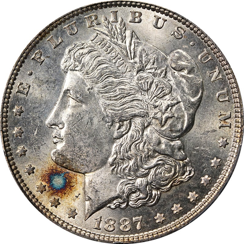 PCGS MS63 1887 Morgan Dollar Philadelphia Silver Coin With Toning: PCGS MS63 1887 Morgan Dollar Philadelphia Silver Coin With Toning This is an 1887-P Morgan Silver Dollar graded MS63 by PCGS. The coin features a vibrant toning burst and is uncirculated. It is compos