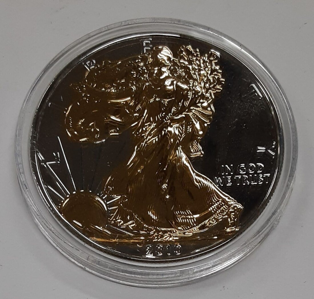 2010 Silver Eagle Dollar Uncirculated with Gold Plated Details in Protective Capsule: 2010 Silver Eagle Dollar Uncirculated with Gold Plated Details in Protective Capsule This 2010 American Silver Eagle coin features brilliant uncirculated condition and showcases gold-plated highlights
