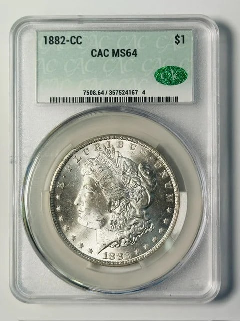 1882 Carson City Morgan Silver Dollar MS 64 CAC: 1882 Carson City Morgan Silver Dollar MS 64 CAC Pre-owned 1882-CC Morgan Silver Dollar graded MS 64 by CACG. This silver dollar was struck in Carson City and features a white appearance. CAC is noted 