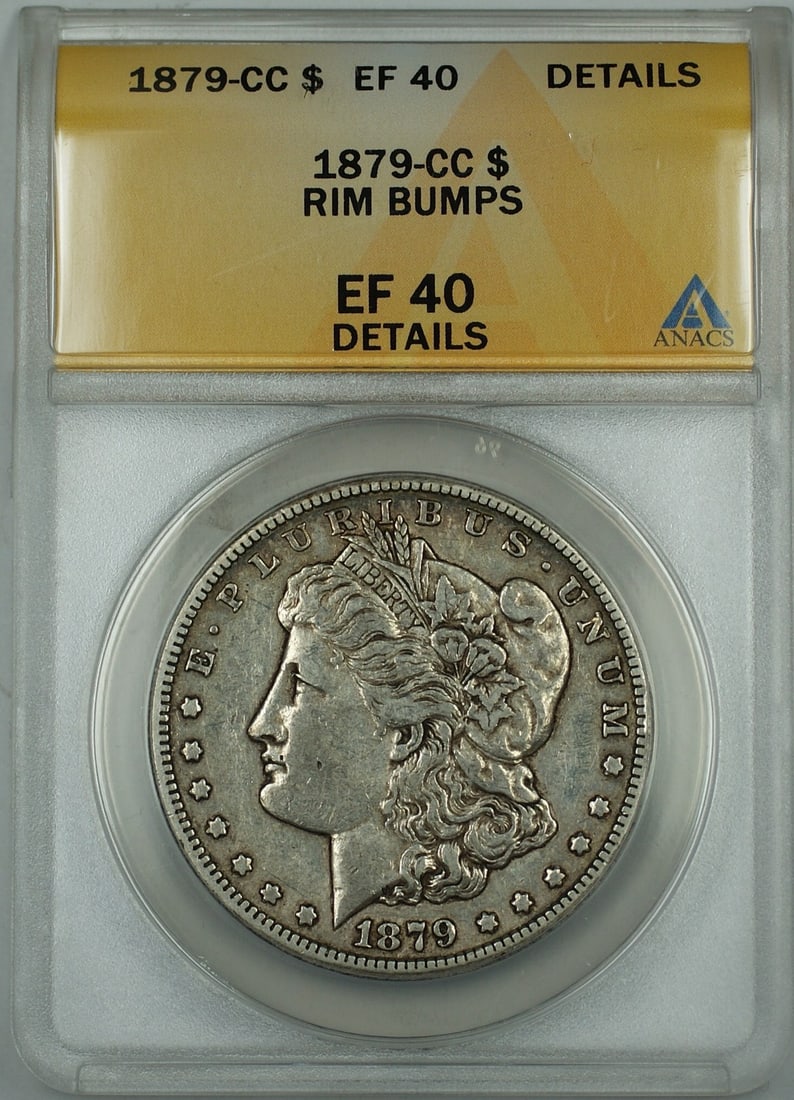 ANACS EF-40 Details 1879-CC Morgan Silver Dollar Rim Bumps: ANACS EF-40 Details 1879-CC Morgan Silver Dollar Rim Bumps 1879-CC Morgan Silver Dollar $1 coin from the United States, certified by ANACS and graded EF-40 Details with rim bumps. This circulated silv
