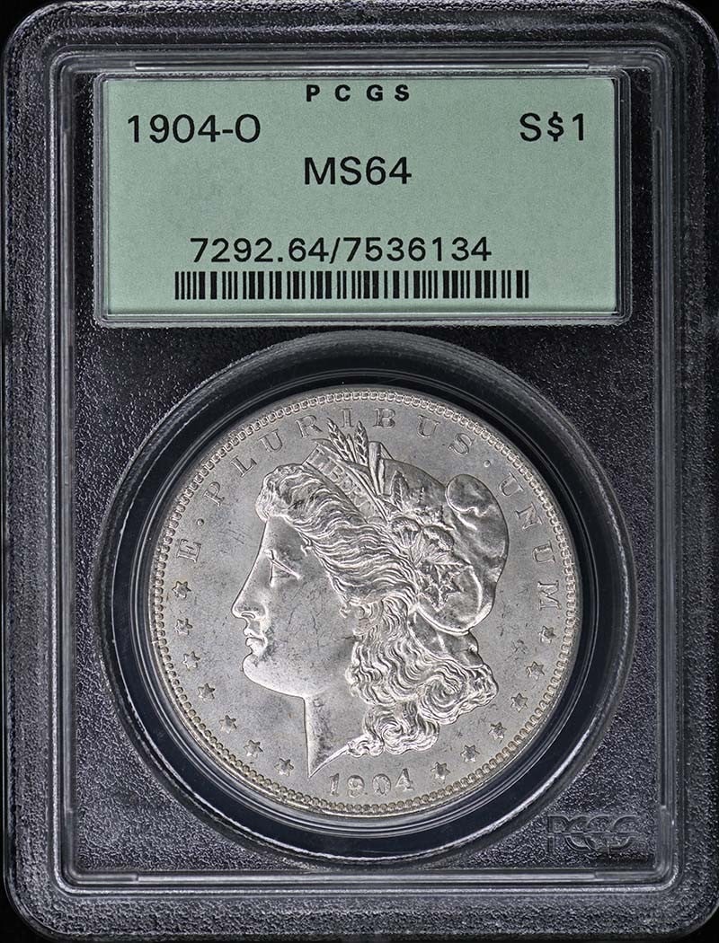 PCGS MS64 1904 O Morgan Silver Dollar OGH: PCGS MS64 1904 O Morgan Silver Dollar OGH 1904-O Morgan Dollar certified by PCGS and graded MS64. This pre-owned coin is an uncirculated United States silver dollar from the Morgan Dollar series. Spec