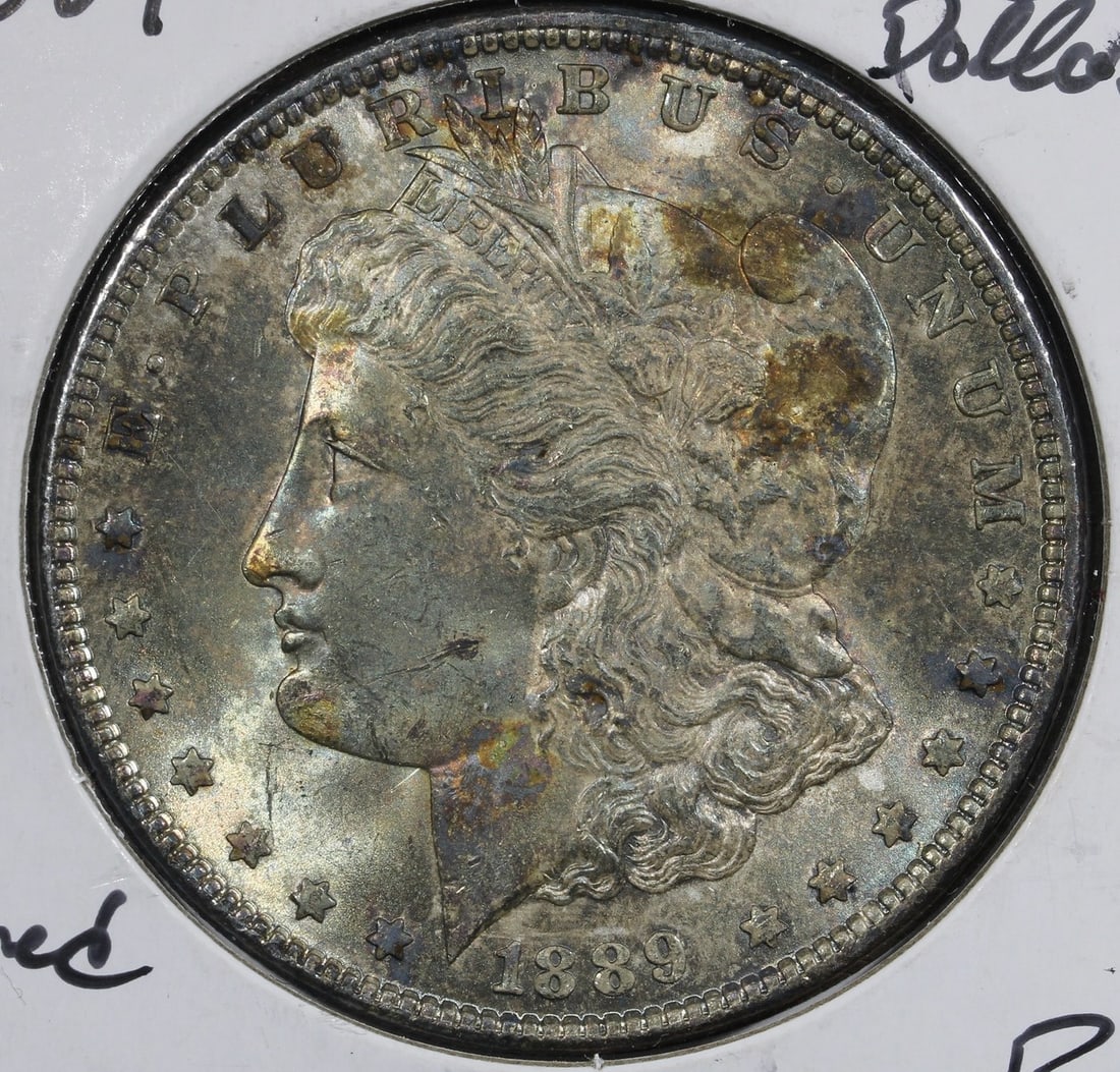 1889 Morgan Dollar Silver Rainbow Toned BU: 1889 Morgan Dollar Silver Rainbow Toned BU This 1889 Morgan Silver Dollar features a beautiful rainbow blue toning and remains in uncirculated condition. Struck in Philadelphia, the coin is composed o