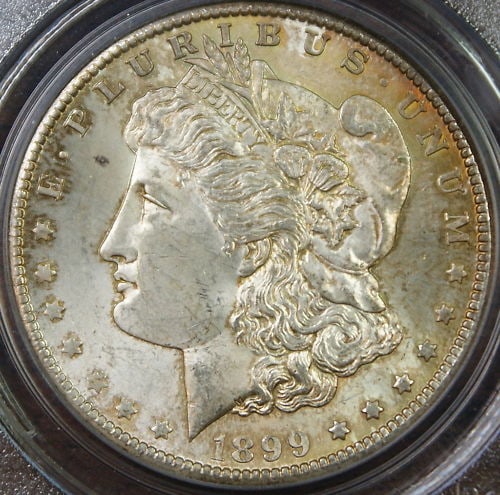 PCGS MS-63 1899-O Morgan Dollar Silver Coin with Attractive Toning: PCGS MS-63 1899-O Morgan Dollar Silver Coin with Attractive Toning This is an 1899-O Morgan Silver Dollar coin, graded MS-63 by PCGS. The coin features attractive toning and was minted in New Orleans.