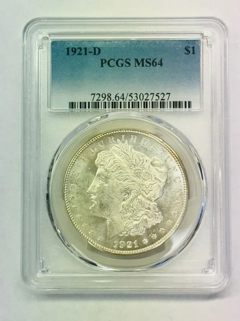 PCGS MS-64 1921 Denver Morgan Silver Dollar: PCGS MS-64 1921 Denver Morgan Silver Dollar This 1921 Morgan Silver Dollar was minted in Denver and is graded MS-64 by PCGS. Composed of silver, this pre-owned coin is a certified example from the USA