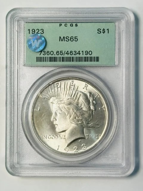 PCGS MS65 1923 Philadelphia Peace Dollar Silver Sight White: PCGS MS65 1923 Philadelphia Peace Dollar Silver Sight White 1923 Peace Dollar certified by PCGS and graded MS 65. This pre-owned silver dollar is described as sight white and is housed in an old green