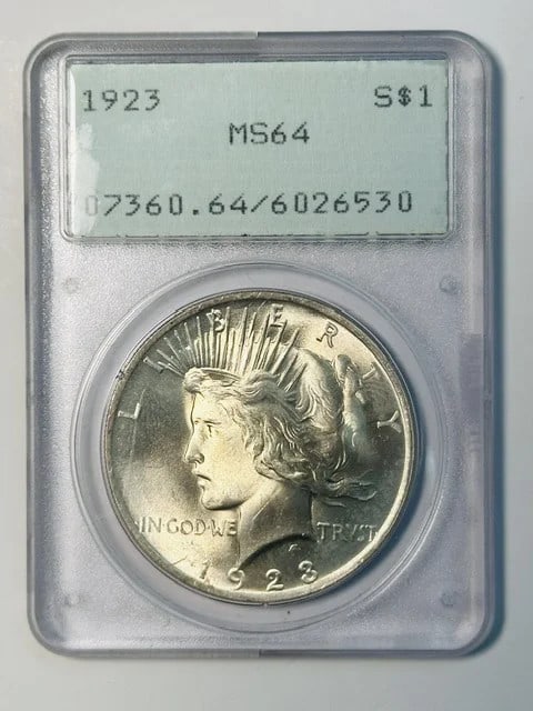 PCGS MS-64 1923 Peace Dollar Silver $1 Philadelphia: PCGS MS-64 1923 Peace Dollar Silver $1 Philadelphia 1923 Peace Dollar certified by PCGS and graded MS-64, housed in a rattler holder. This silver dollar is a pre-owned coin struck in the USA with a Ph