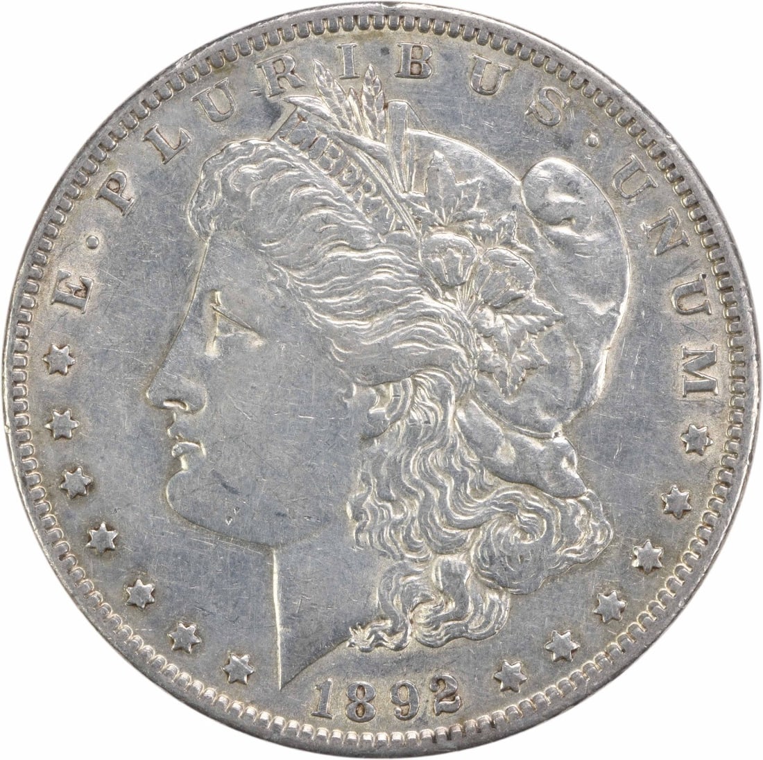 1892 Morgan Silver Dollar AU Circulated Philadelphia Mint: 1892 Morgan Silver Dollar AU Circulated Philadelphia Mint This 1892 Morgan Silver Dollar is a remarkable piece of history, showcasing the artistry of designer George T. Morgan. With a grade of AU (Abo
