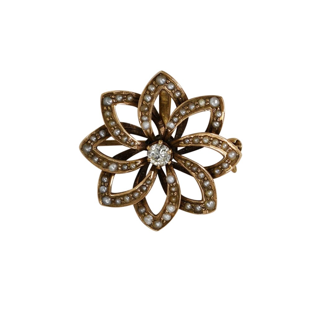 Vintage 12K Yellow Gold Floral Brooch with Diamond and Seed Pearls: Vintage 12K Yellow Gold Floral Brooch with Diamond and Seed Pearls Vintage floral pin crafted in 12k yellow gold, featuring a natural round brilliant diamond accented by seed pearls. This pre-owned br