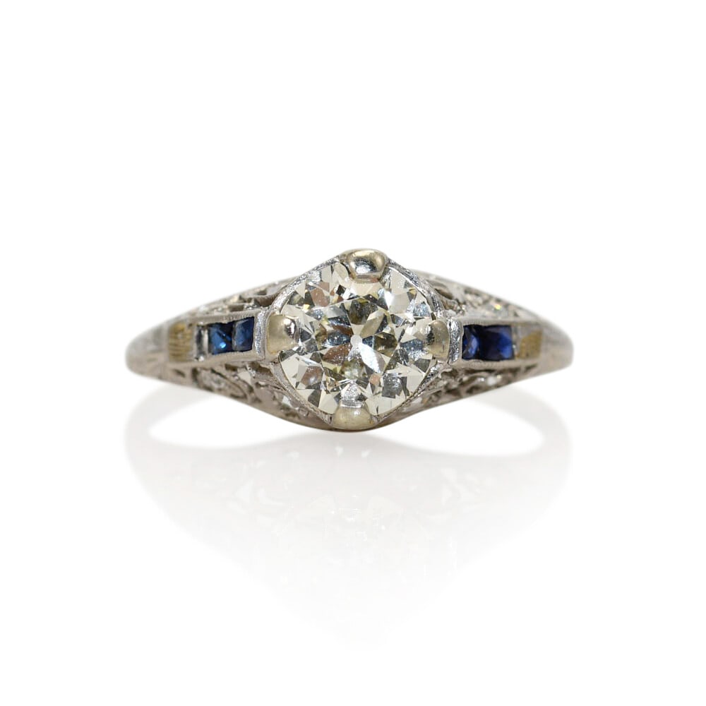 Art Deco Platinum Ring with 1.00ct Euro Cut Diamond and Sapphires: Art Deco Platinum Ring with 1.00ct Euro Cut Diamond and Sapphires Art Deco ring crafted in platinum with natural diamonds and small blue sapphires. The centerpiece is an old Euro cut diamond, accented
