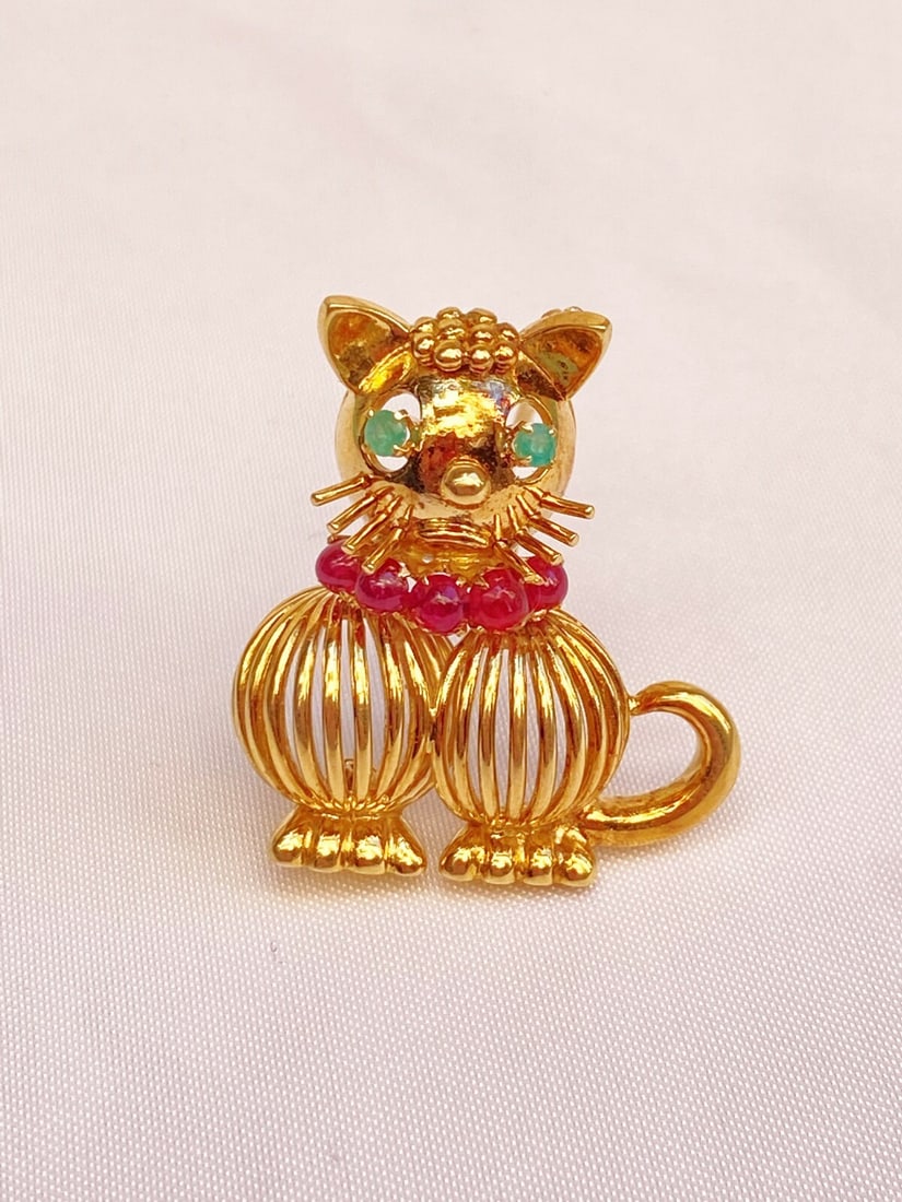 1963 Hans George Mautner 18K Gold Ruby Emerald Cat Brooch: 1963 Hans George Mautner 18K Gold Ruby Emerald Cat Brooch This exquisite brooch from 1963 showcases the artistry of Hans George Mautner, crafted in England from luxurious 18K yellow gold. The design f