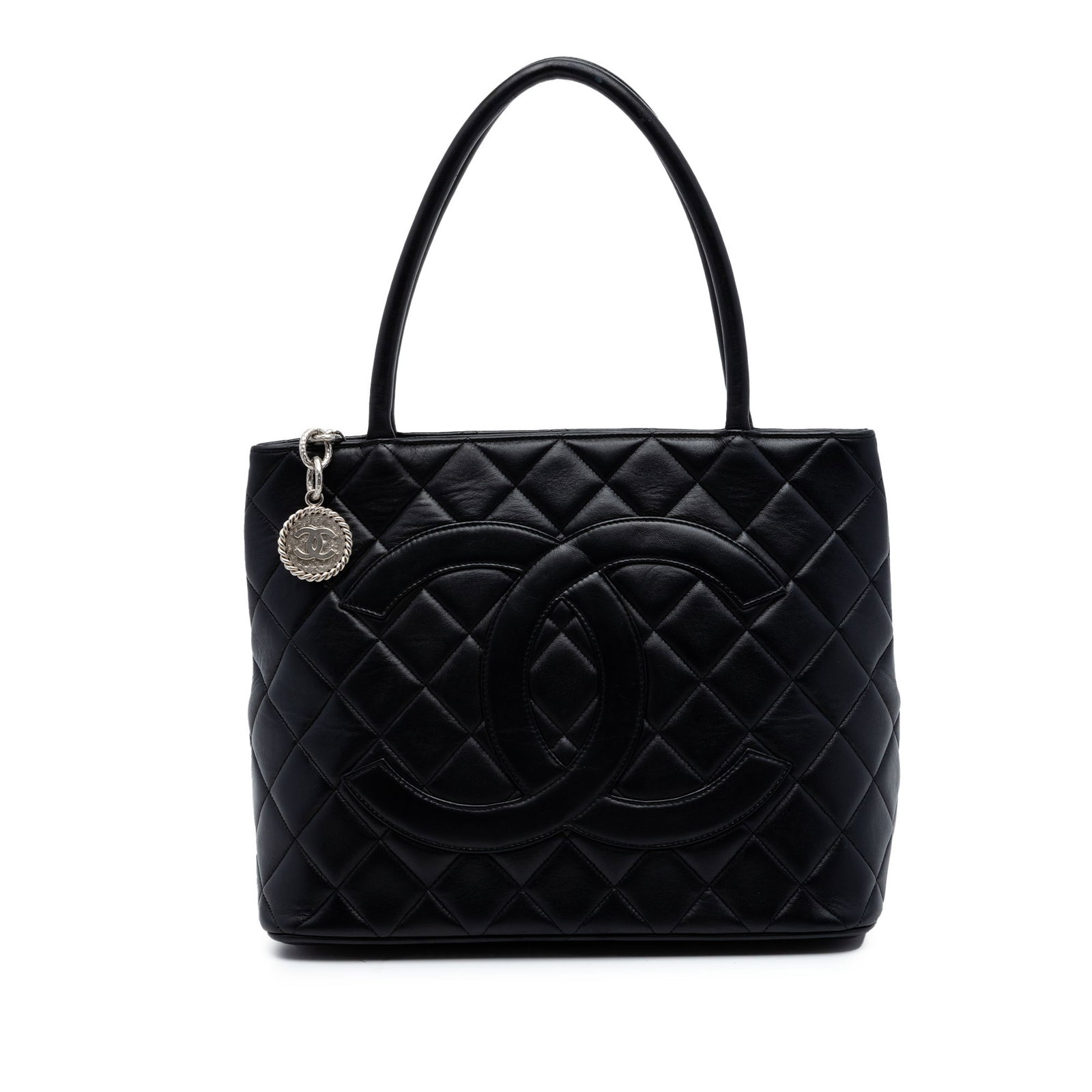 Chanel black quilted lambskin tote bag: Chanel black quilted lambskin tote bag This Chanel Lambskin Medallion Tote features a classic quilted lambskin leather exterior in black, complemented by rolled leather handles and a top zip closure. 