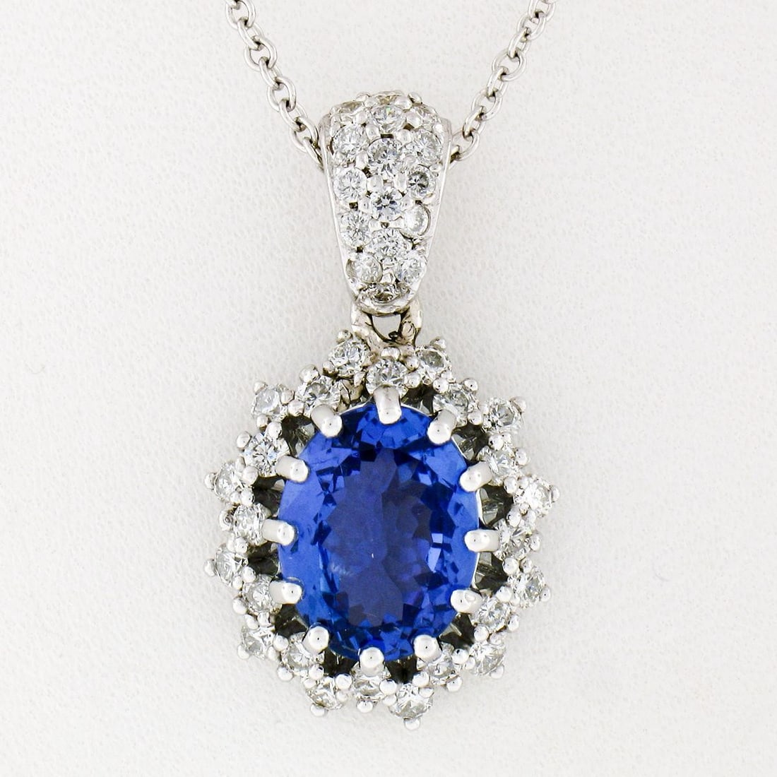 Unbranded Oval Tanzanite Diamond Halo Pendant Necklace 14k White Gold: Unbranded Oval Tanzanite Diamond Halo Pendant Necklace 14k White Gold Un-used 14k white gold pendant necklace featuring an oval natural tanzanite framed by a dual halo of natural diamonds. The pendant