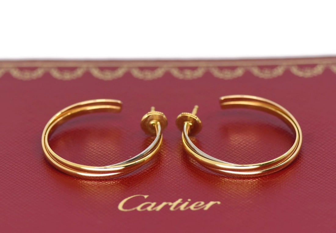 Cartier Trinity 18K Multi Tone Gold Hoop Earrings 30MM: Cartier Trinity 18K Multi Tone Gold Hoop Earrings 30MM These Cartier Trinity earrings are crafted from 18K tri-color gold, featuring a classic hoop style. The design showcases intertwined bands of mul