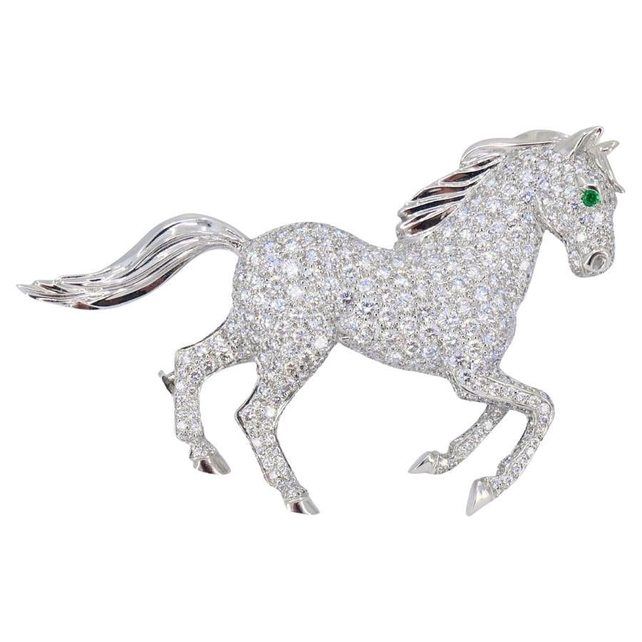 Cartier 18k White Gold Horse Brooch with Diamonds and Emerald: Cartier 18k White Gold Horse Brooch with Diamonds and Emerald Vintage Cartier horse brooch in 18k gold, set with round brilliant-cut diamonds and an emerald eye. The design depicts a galloping horse w