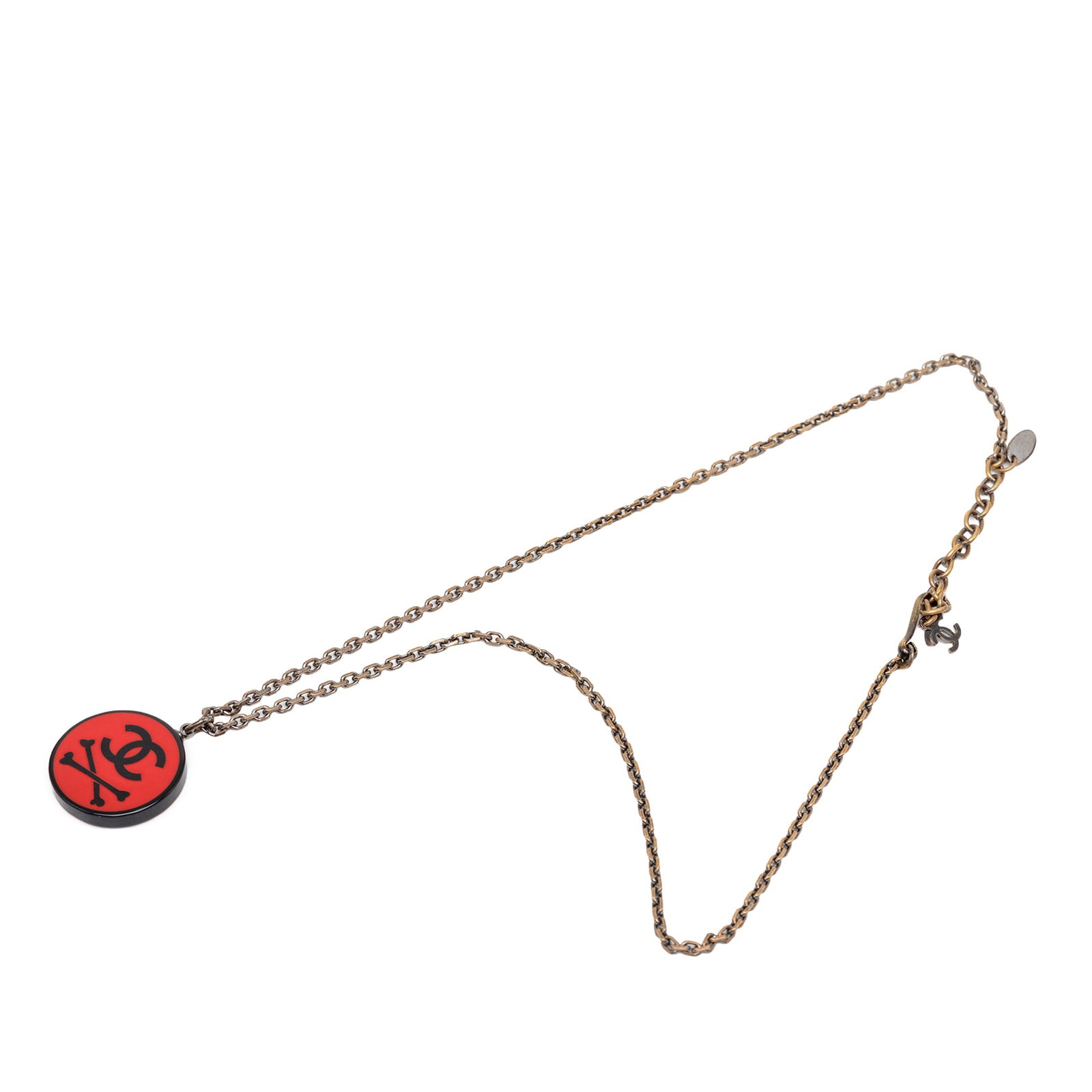 Chanel Crossbones Pendant Necklace Red Resin Gold Tone CC: Chanel Crossbones Pendant Necklace Red Resin Gold Tone CC Round pendant necklace with a resin crossbones motif and a gold-tone chain. The piece is attributed to Chanel and made in France. Condition is