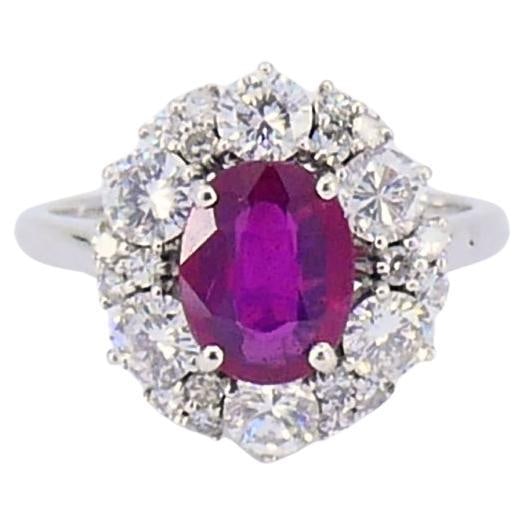 Burma Ruby and Diamond Cluster Ring in 18k White Gold 1.75ct: Burma Ruby and Diamond Cluster Ring in 18k White Gold 1.75ct Vintage cluster ring in 18k white gold featuring a 1.75 ct natural ruby of Burma origin framed by a halo of round-cut diamonds. The ring ha
