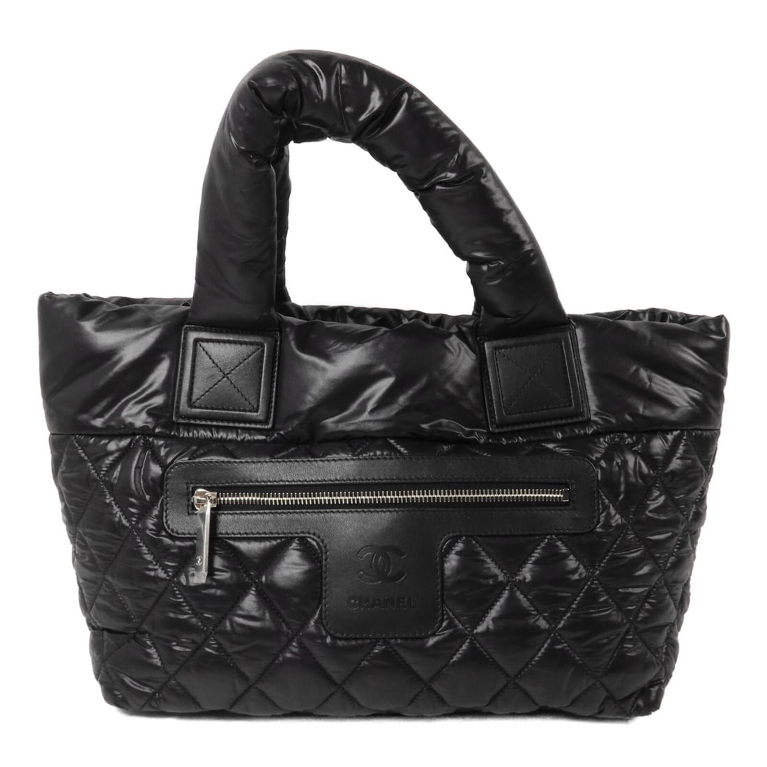 CHANEL Cocoon CC Tote Bag Black Nylon SHW: CHANEL Cocoon CC Tote Bag Black Nylon SHW Chanel Cocoon tote bag in black nylon with CC SHW styling. This women's tote features a spacious silhouette with zip pockets inside and out, and includes a ho