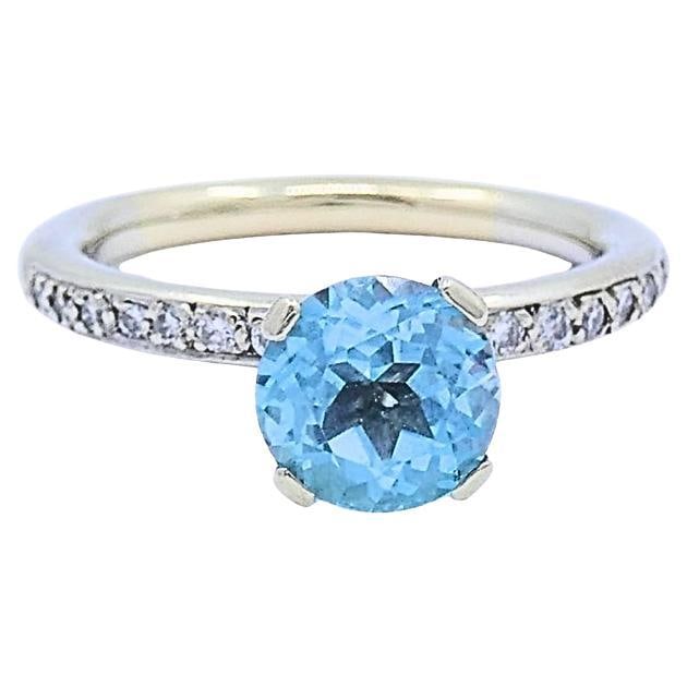 Size 7 14k Gold Ring with Blue Topaz and Diamond Accents: Size 7 14k Gold Ring with Blue Topaz and Diamond Accents A 14k gold ring featuring a round blue topaz center stone in a classic four-prong solitaire setting, accented by a slim band with small round d