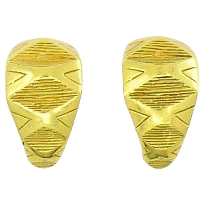 Pair of 18K Yellow Gold Hoop Earrings with Engraved Geometric Motif: Pair of 18K Yellow Gold Hoop Earrings with Engraved Geometric Motif A pair of 18k yellow gold hoop earrings with a geometric design, featuring fine engravings and raised details. The surface includes 