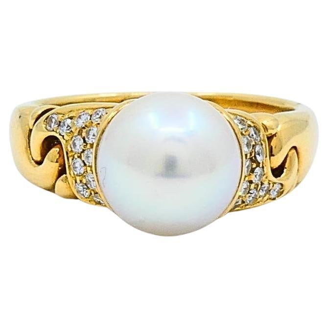 Bulgari Pearl and Diamond Ring in 18K Yellow Gold: Bulgari Pearl and Diamond Ring in 18K Yellow Gold Bvlgari pearl and diamond cocktail ring crafted in 18k gold, featuring a white pearl accented by pave-set diamonds. This 1990s design reflects the hou
