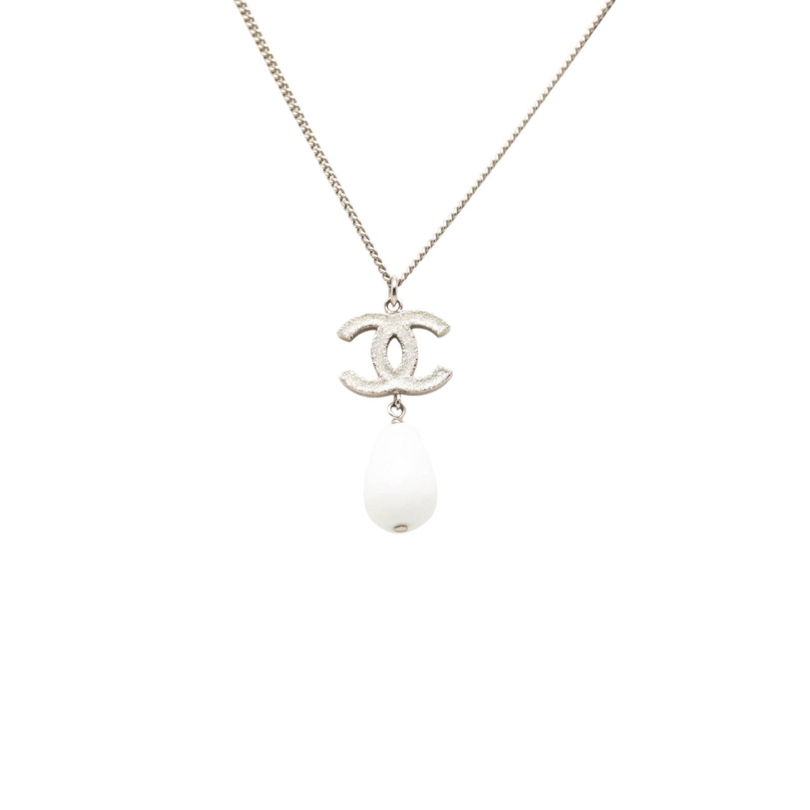 Chanel CC pendant necklace with faux pearl silver tone metal: Chanel CC pendant necklace with faux pearl silver tone metal Chanel CC pendant necklace in silver-tone metal with a faux pearl accent and lobster clasp closure. This costume jewelry piece is made in