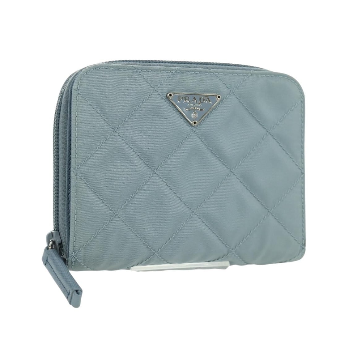 Prada Light Blue Nylon Round Compact Wallet 1ML605 Women's Accessory: Prada Light Blue Nylon Round Compact Wallet 1ML605 Women's Accessory This PRADA round compact wallet is crafted from light blue nylon and designed for women. It features a compact silhouette with appr