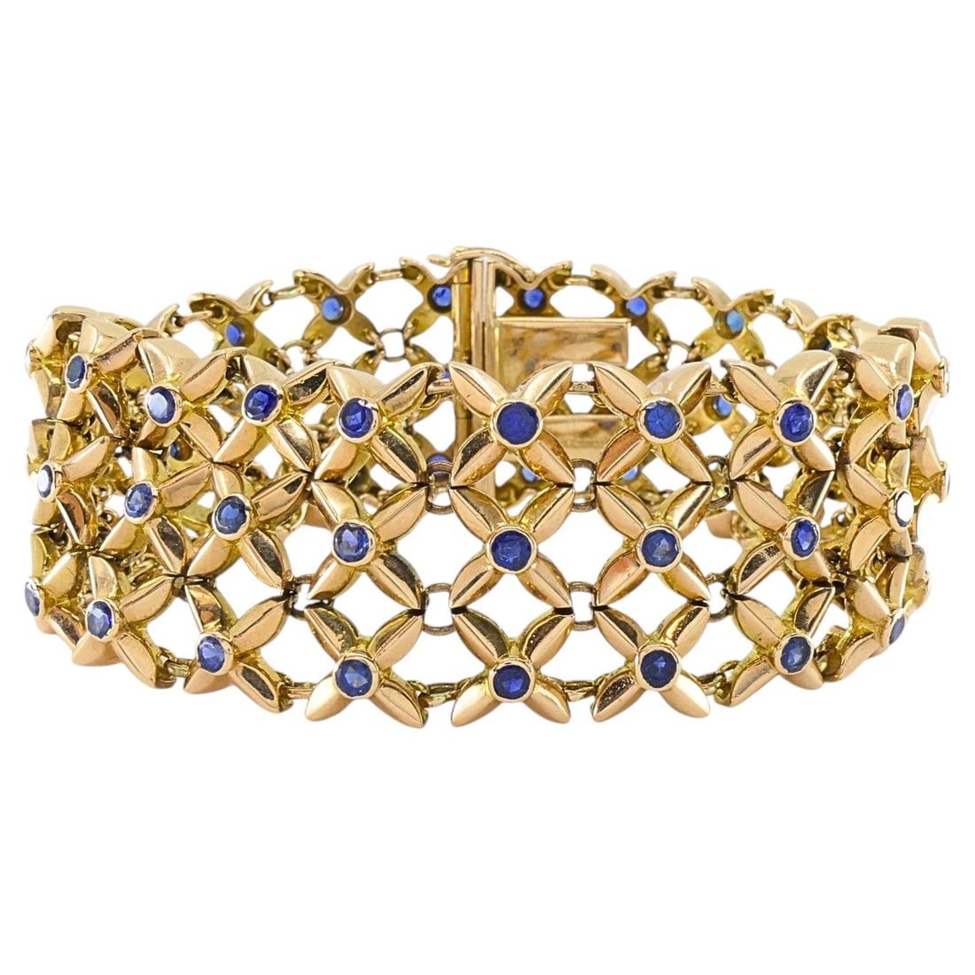 Boucheron Sapphire Bracelet in 18k Gold Wide Openwork Mesh: Boucheron Sapphire Bracelet in 18k Gold Wide Openwork Mesh Vintage Boucheron bracelet crafted in 18k gold and set with round blue sapphires throughout. It features an open lattice of petal-shaped gold