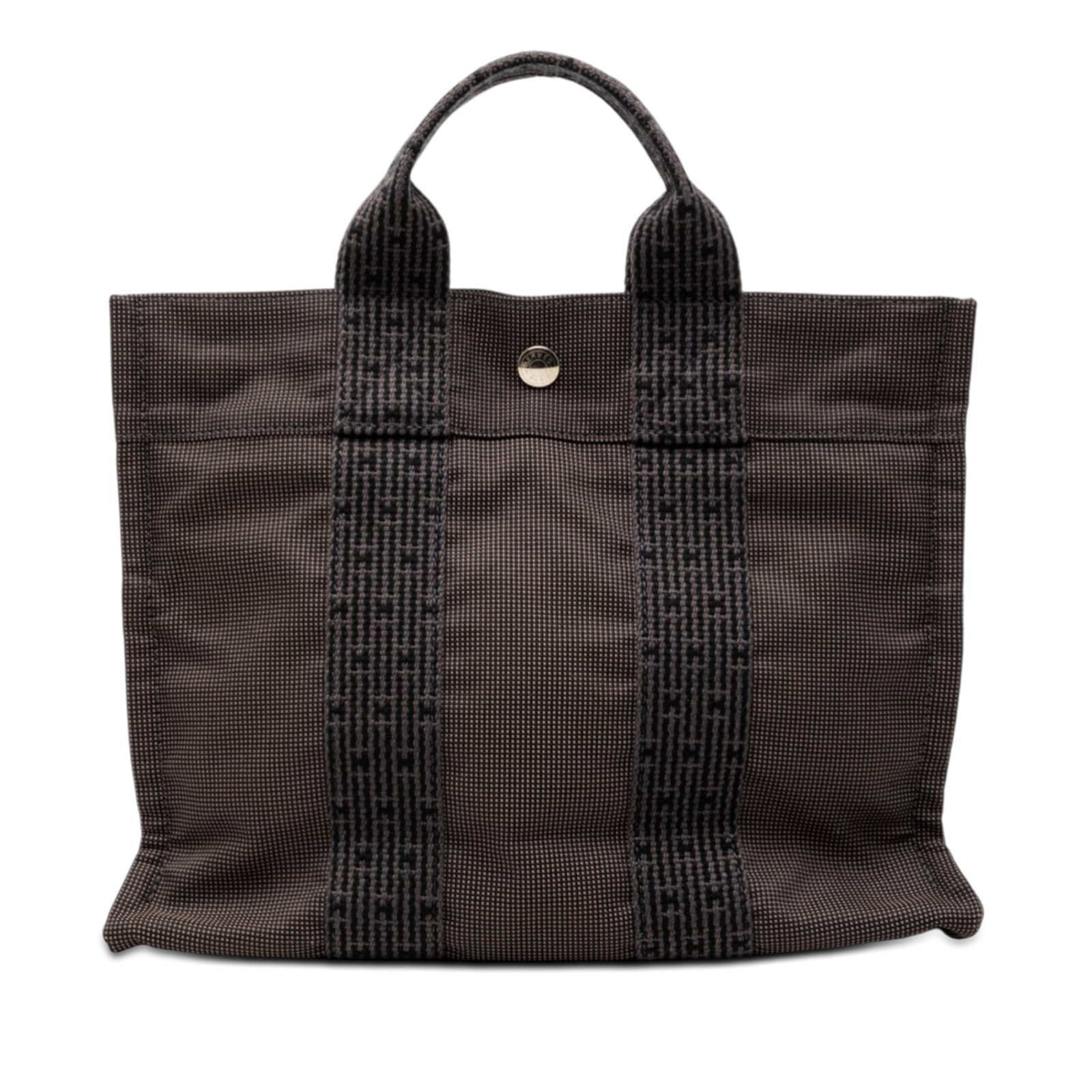Hermes Herline PM gray canvas tote: Hermes Herline PM gray canvas tote This Hermes Herline PM bag features a gray canvas body with flat straps, an open top secured by a snap closure, and an interior zip compartment. The bag shows visibl