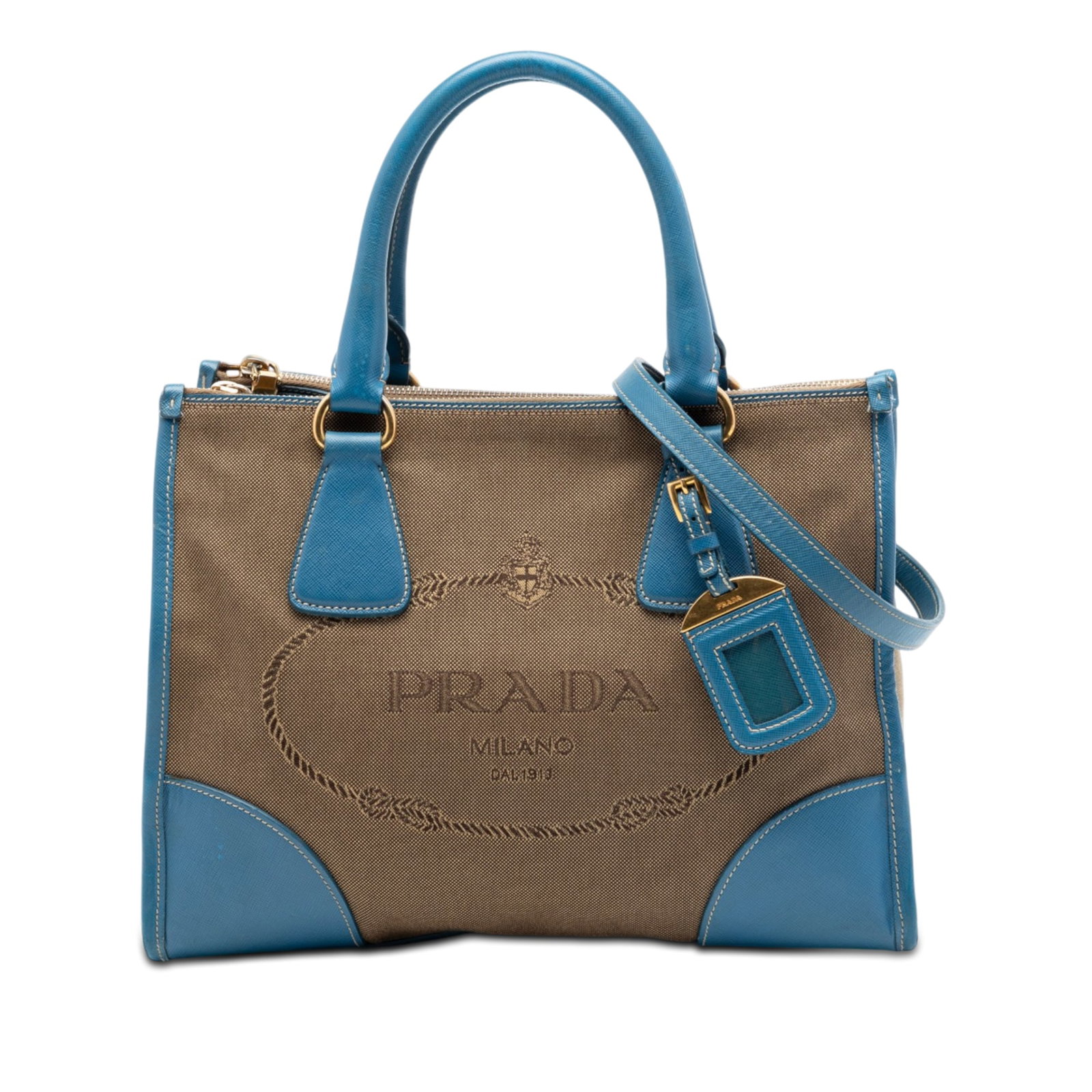 Prada Canapa Logo Double Zip Satchel in Brown Canvas: Prada Canapa Logo Double Zip Satchel in Brown Canvas Prada Canapa satchel crafted with a canvas body and saffiano leather trim. The design features rolled leather handles, a detachable flat strap, an 
