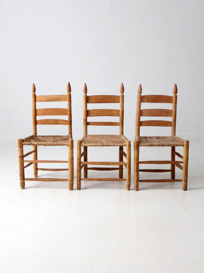 Rustic Vintage Ladder Back Chairs Set of 3 with Woven Seats: Rustic Vintage Ladder Back Chairs Set of 3 with Woven Seats This charming set of three vintage ladder-back chairs showcases a delightful rustic aesthetic. Crafted with woven seats and sturdy turned wo
