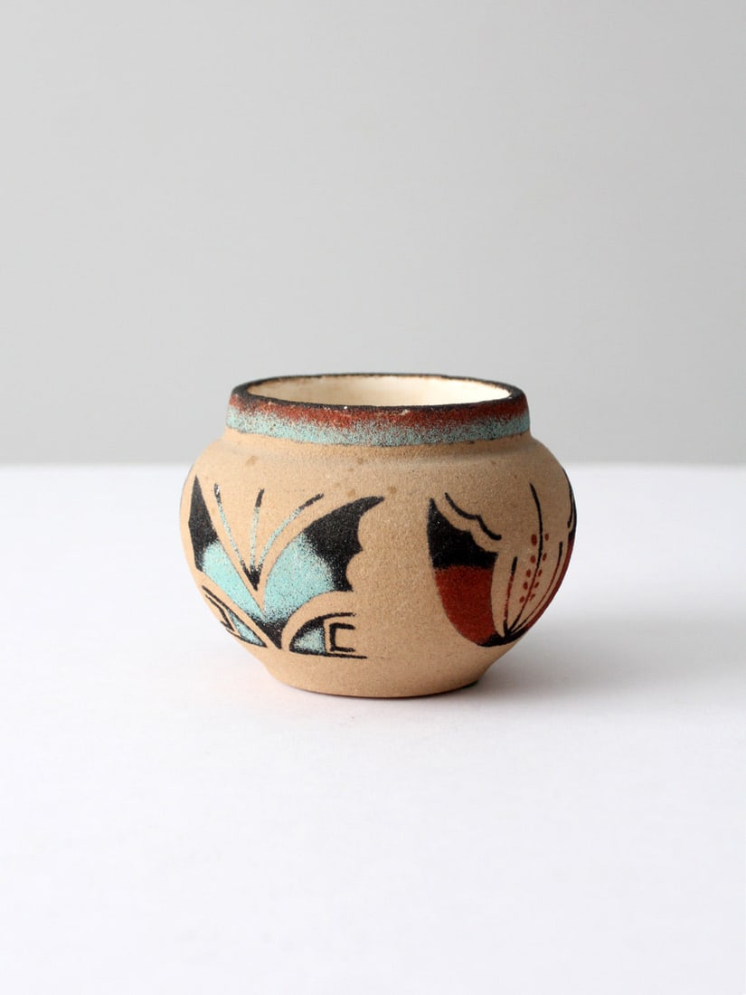 Vintage Navajo Sand Art Vase Signed by Willie Butterfly Design: Vintage Navajo Sand Art Vase Signed by Willie Butterfly Design This vintage Navajo sand art vase features a beautifully crafted butterfly design in vibrant turquoise blue, rust red, and black hues. Ha