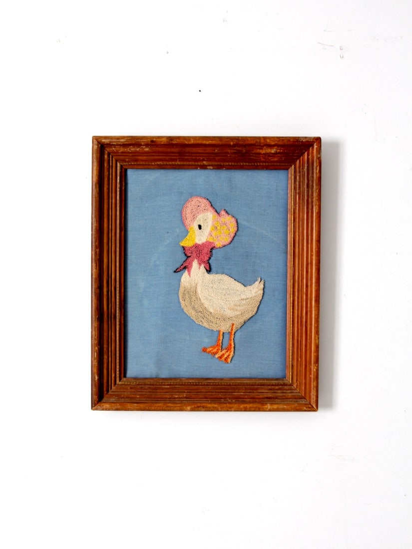 Vintage Mother Goose Embroidery in Wood Frame 17.5 x 14.5: Vintage Mother Goose Embroidery in Wood Frame 17.5 x 14.5 This vintage framed Mother Goose embroidery adds a charming storybook touch to any space, evoking a sense of nostalgia. The piece features a d