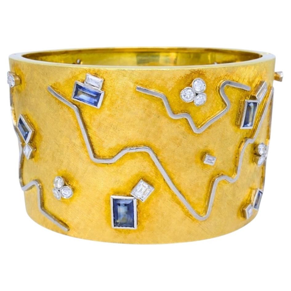 Vintage 18k Yellow and White Gold Cuff Bangle with Diamonds and Sapphires: Vintage 18k Yellow and White Gold Cuff Bangle with Diamonds and Sapphires Vintage 18k gold cuff bracelet with an extra wide bangle design, accented with diamonds and sapphires. The textured yellow gol