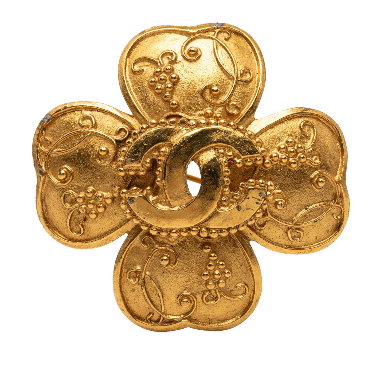Chanel CC Grapevine Clover Brooch Gold Tone Metal: Chanel CC Grapevine Clover Brooch Gold Tone Metal Chanel CC Grapevine Clover brooch in gold-plated metal with a back pin closure. This costume jewelry piece is made in France and includes the box. Con