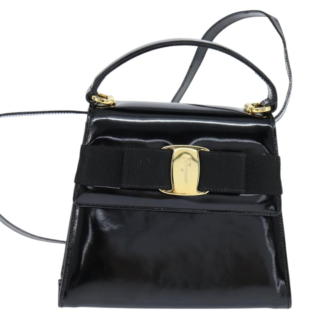 Black Patent Leather Vala Handbag by Salvatore Ferragamo: Black Patent Leather Vala Handbag by Salvatore Ferragamo This Salvatore Ferragamo Vala handbag for women is crafted from black patent leather. It features a compact design with dimensions of 19cm x 15