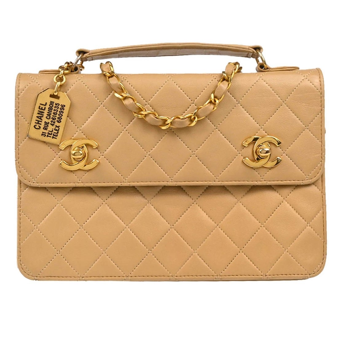 CHANEL CC beige lambskin top handle bag with strap: CHANEL CC beige lambskin top handle bag with strap Chanel 2way handbag in beige lambskin with a top handle bag style and non-adjustable strap. It features a leather lining, logo accent, and the Chanel
