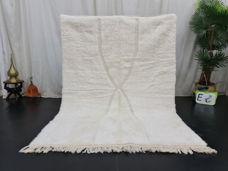 Authentic Handmade Moroccan Berber Wool Rug 8 x 5 Feet: Authentic Handmade Moroccan Berber Wool Rug 8 x 5 Feet Elevate your home decor with this authentic soft white handmade Moroccan Berber wool rug, featuring a beautifully engraved pattern. Handwoven by 