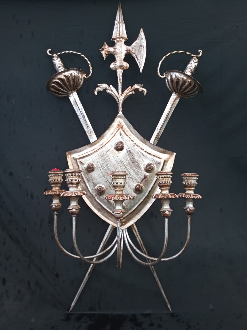 40 inch vintage gilt tole wall sconce with sword crest 5 lights: 40 inch vintage gilt tole wall sconce with sword crest 5 lights Vintage wall sconce featuring a silver gilt tole and carved wood design with a sword and armorial shield motif. This 5-candle piece has 